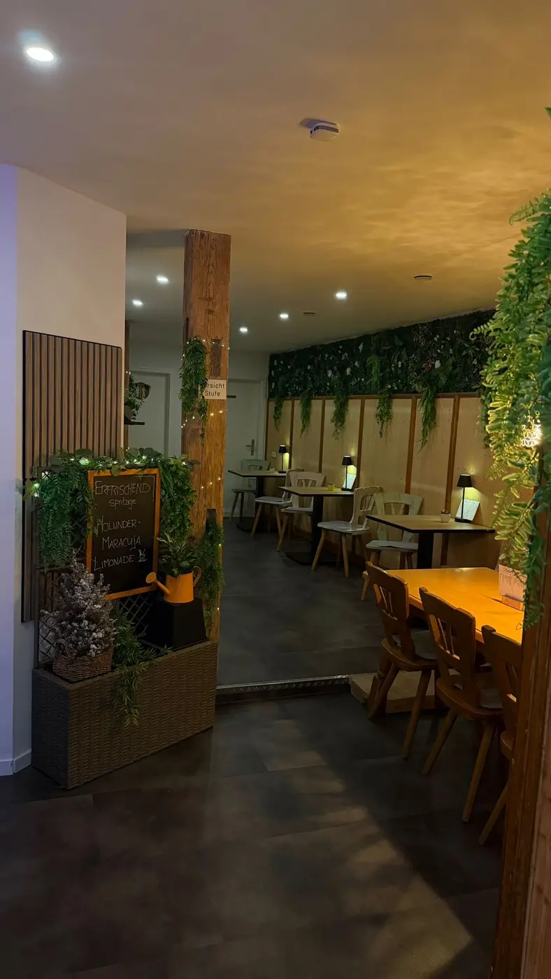 Gemütlicher Café-Bereich mit Pflanzen im Bistro 21 Lichtenfels